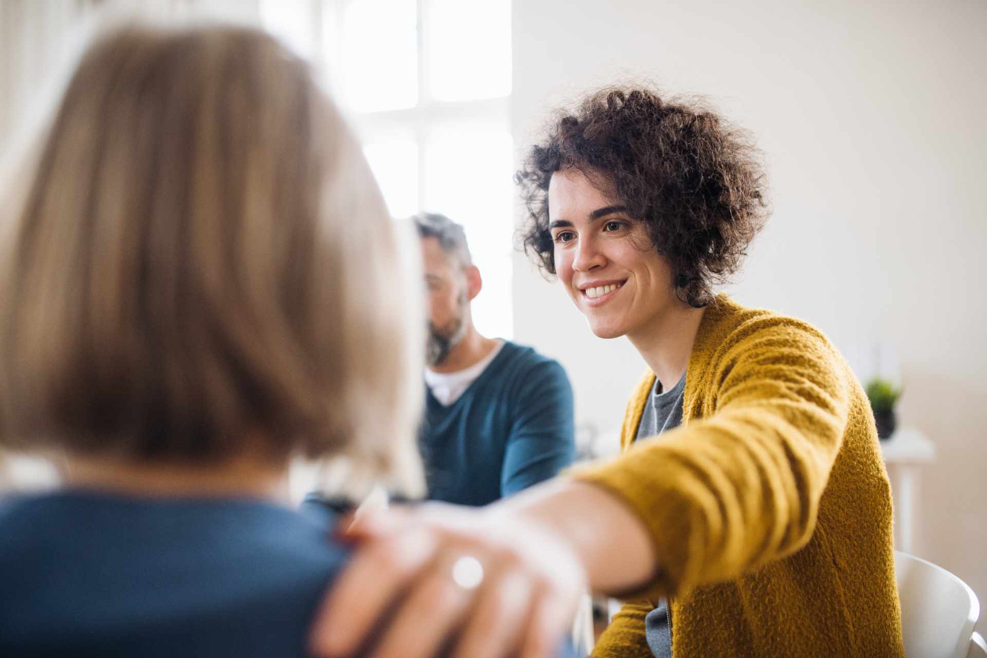 Homens e mulheres sentados em círculo discutindo como obter o certificado de saúde mental